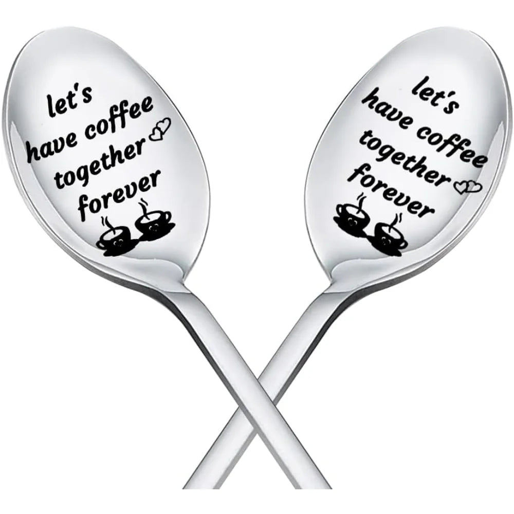 Two silver spoons with engraved text 'Let's have coffee together forever' on a white background