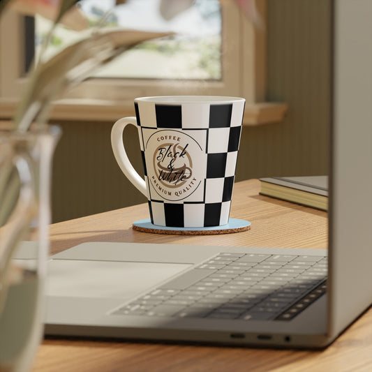 Chic Checkered Latte Mug with black and white checkered pattern sitting on a wooden desk near a laptop.